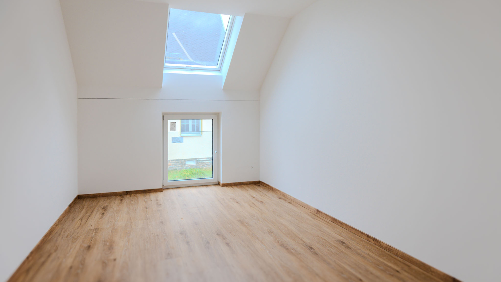 Modernes Schlafzimmer im Dachgeschoss mit Dachschrägen, einem Velux-Dachfenster und hellem Bodenbelag